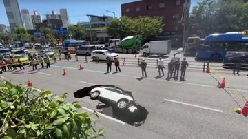 Cratera gigantesca se abre no meio de avenida e engole carro - Reprodução/Reuters via Newsflare