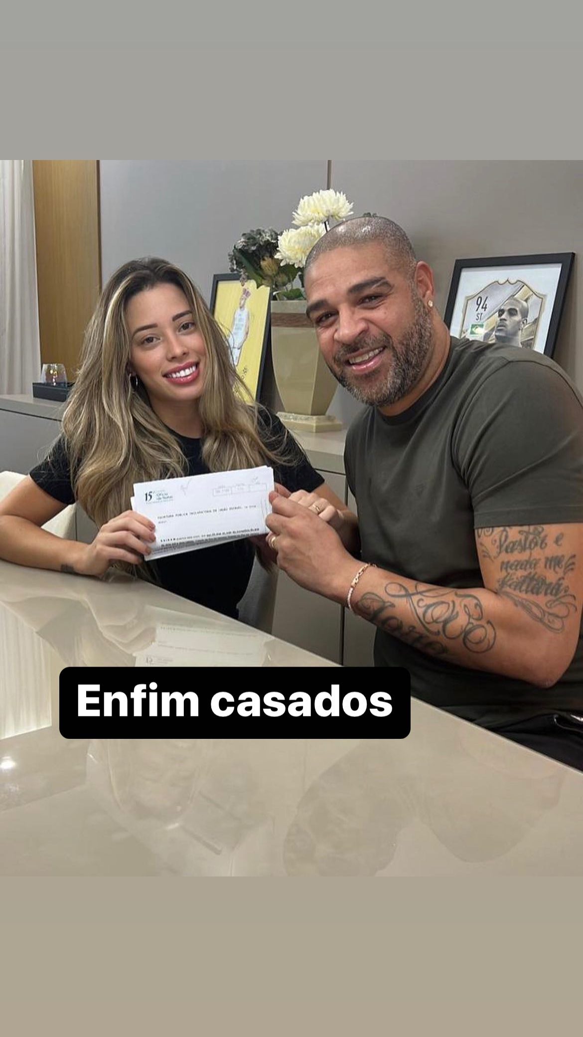 Adriano Imperador e Micaela Mesquita posam com certidão de casamento