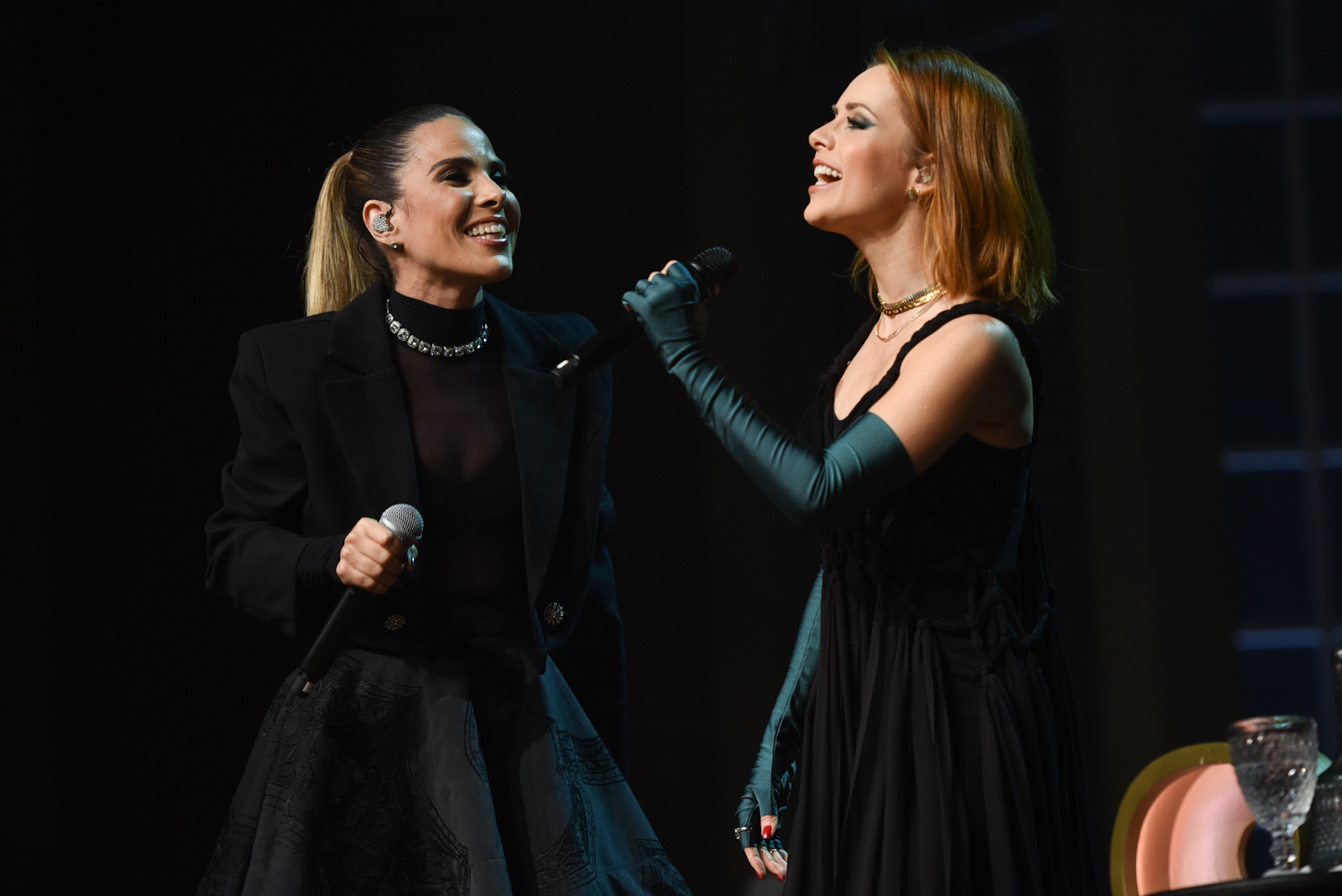 Foto de Wanessa e Sandy dividindo um palco enquanto cantam