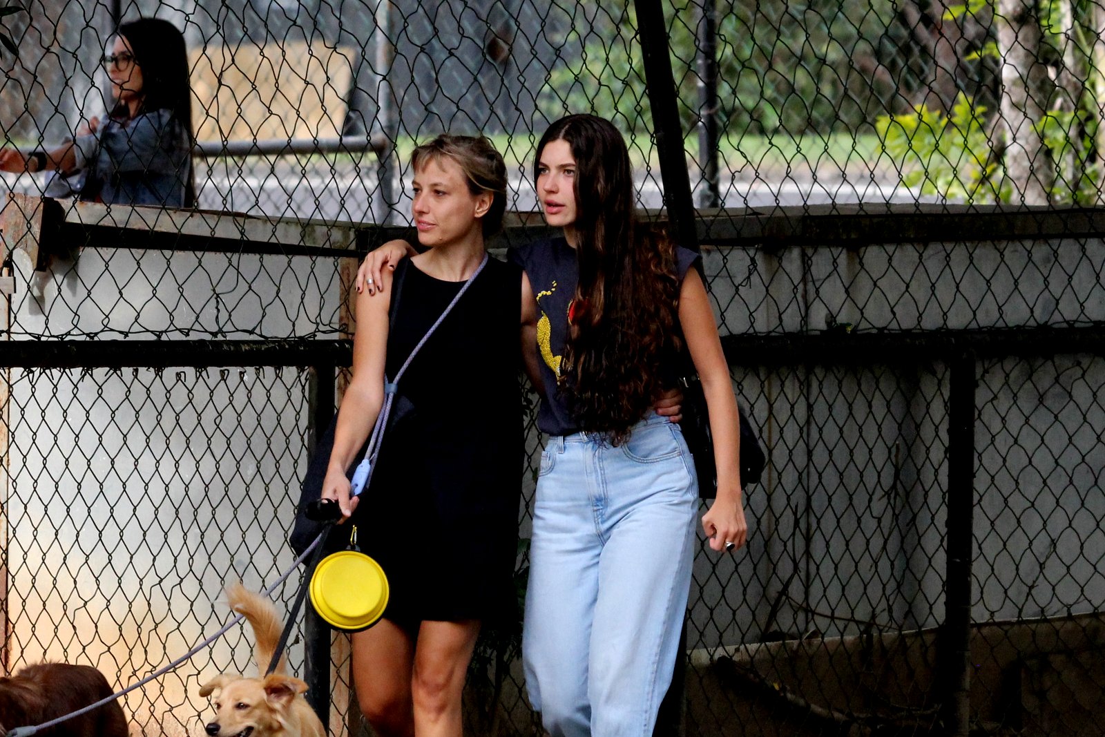 Foto de Alanis Guillen abraçada a uma mulher loira enquanto anda por um parque