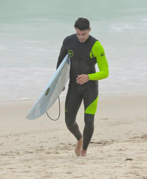 Cauã Reymond curte dia de surfe na praia