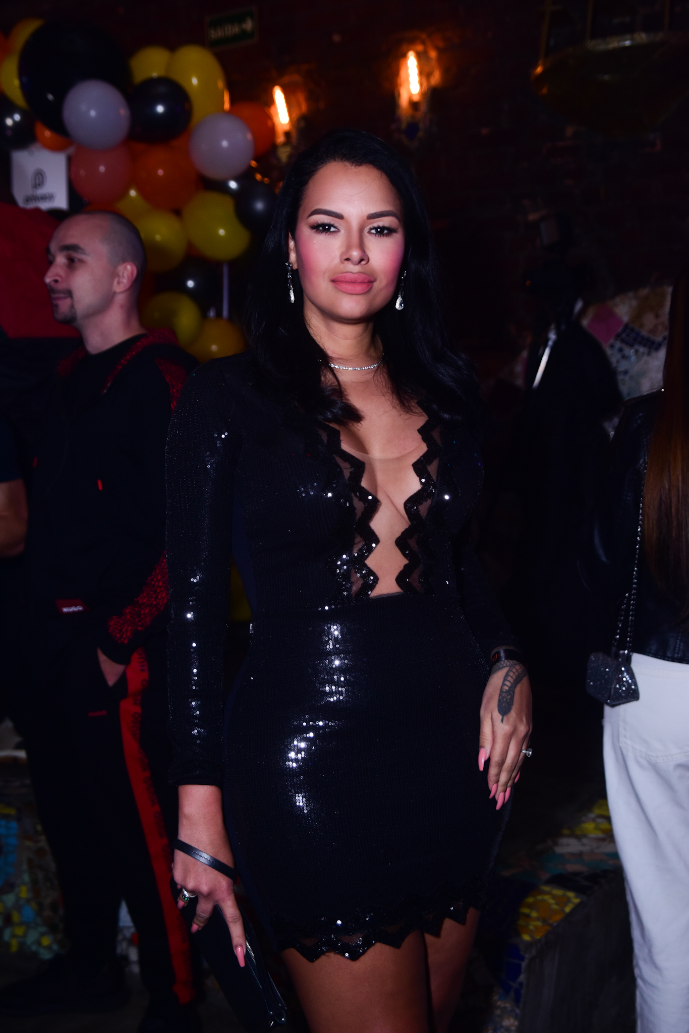 Foto de Ariadna Arantes com vestido preto e decotado em festa