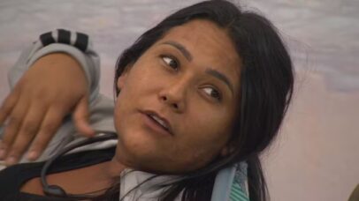 Mulher de cabelos escuros e pele morena, com expressão pensativa, em close-up.