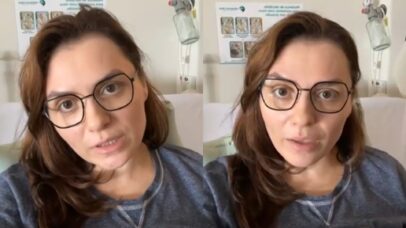 Mulher com óculos e cabelo castanho em um quarto de hospital, falando para a câmera. Ao fundo, um pôster informativo e equip…