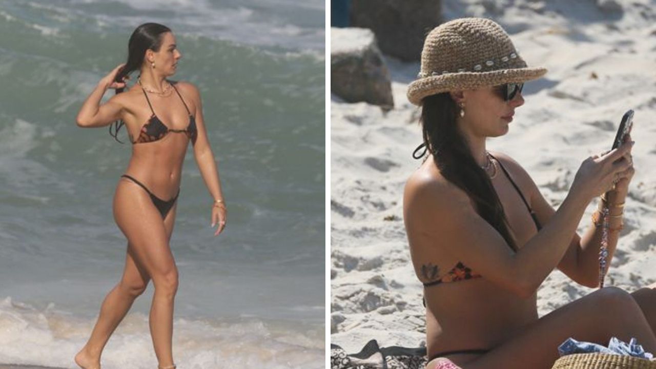 Dona de um corpo perfeito, Isis Valverde vai de fio-dental para a praia e se refresca em um banho de mar