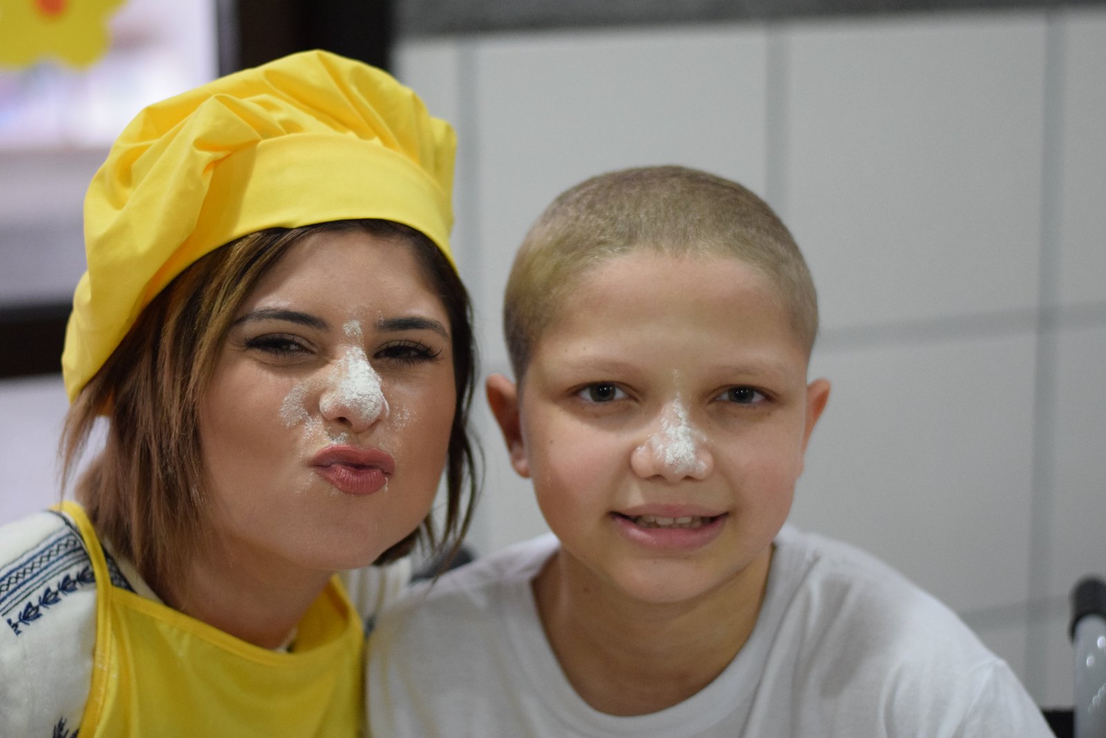 Julianne Trevisol cozinha ao lado crianças com câncer