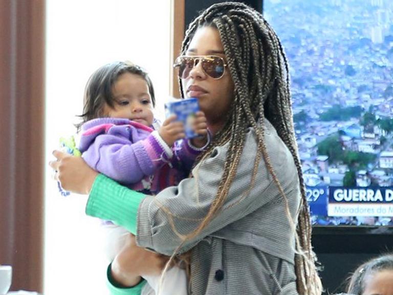Com novo visual, atriz Juliana Alves embarca com a filha nos braços no Rio