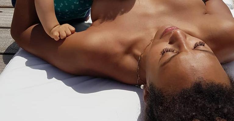 Sheron Menezzes posa amamentando o filho enquanto toma sol