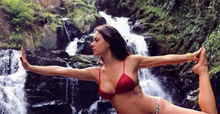 Em sua cidade natal, Isis Valverde se equilibra em pedra com seu barrigão de 8 meses