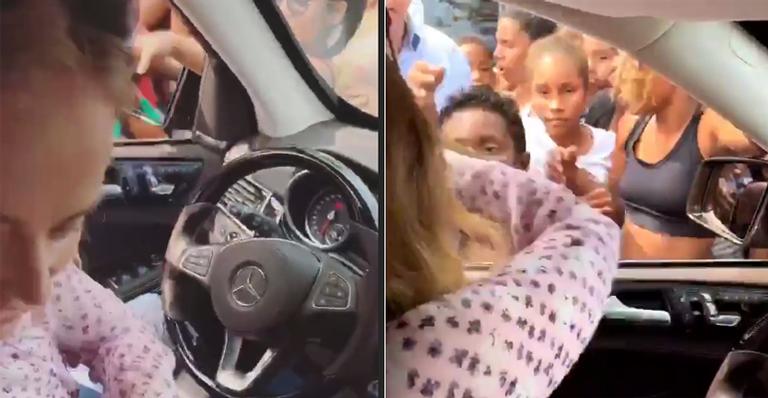 Angélica e Luciano Huck distribuem doces em comunidade