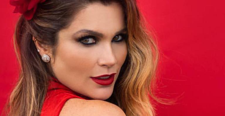 Flávia Alessandra surge supermaquiada com vestido vermelho sexy e faz clima esquentar