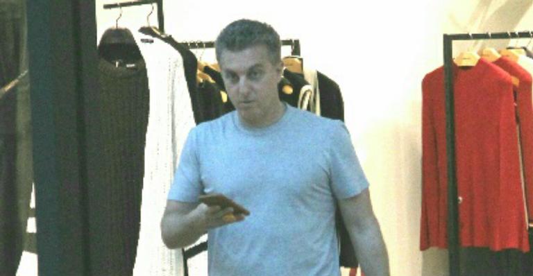 Após susto, Luciano Huck passeia sozinho pelo shopping e sai com sacola grifada