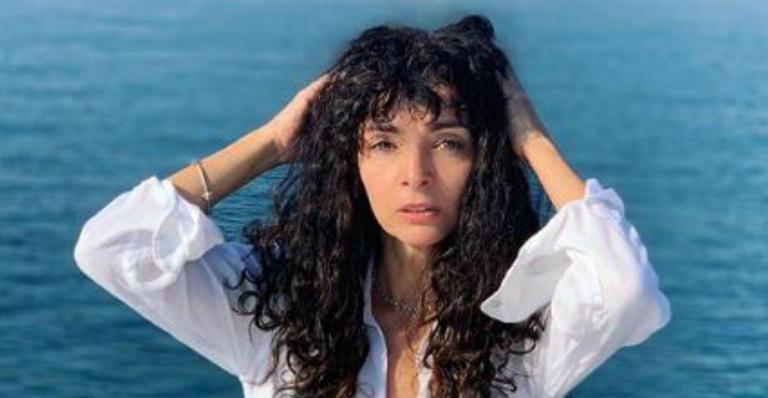 Aos 56 anos, Claudia Ohana surge com camiseta curtinha e deixa barriguinha seca a mostra
