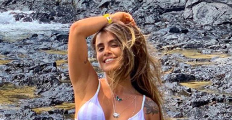 De biquíni branco, Carol Peixinho exibe barriga sarada na praia