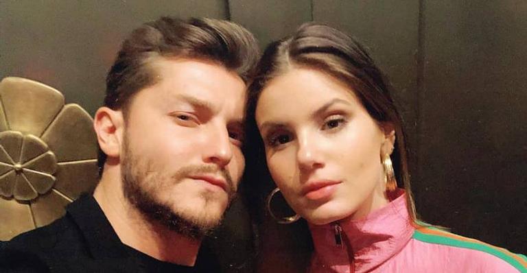 Klebber Toledo e Camila Queiroz posam em frente a letreiro famoso nos EUA