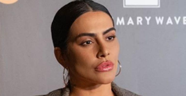 Cleo causa em evento com make pode poderosa, fenda arrasadora e vestido de cetim