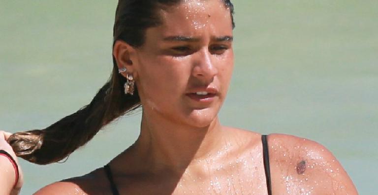 Filha de Flávia Alessandra, Giulia Costa abaixa biquíni na praia e quase mostra demais