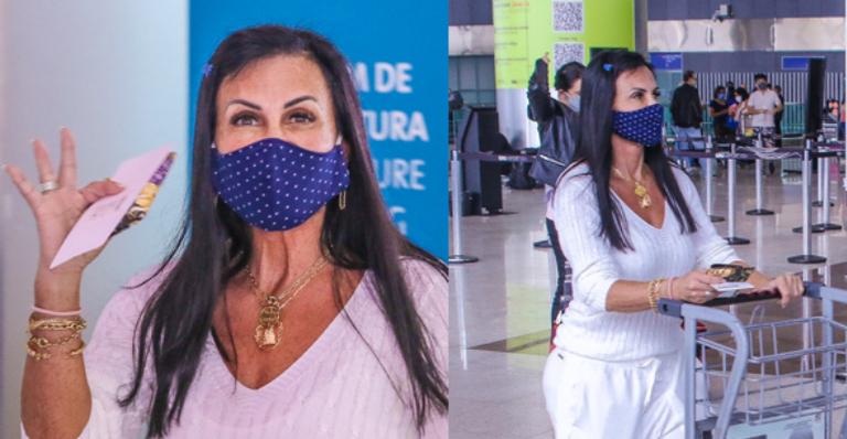 Sozinha e de máscara, Gretchen embarca em aeroporto com destino à Europa