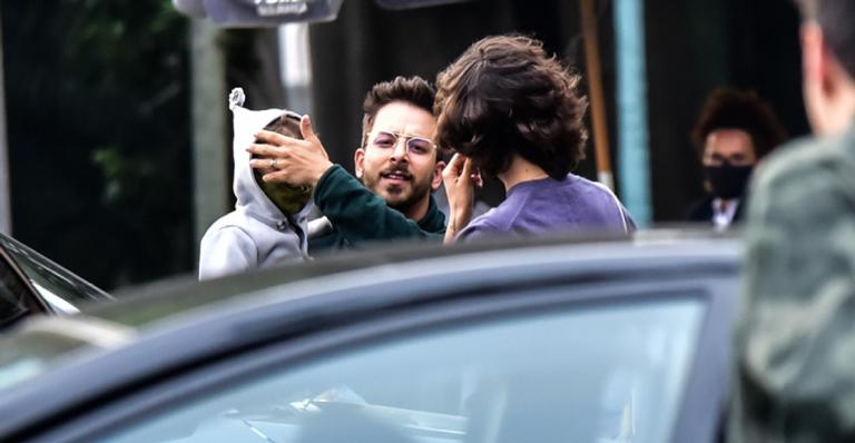 Júnior Lima protege rosto do herdeiro ao notar que está sendo fotografado