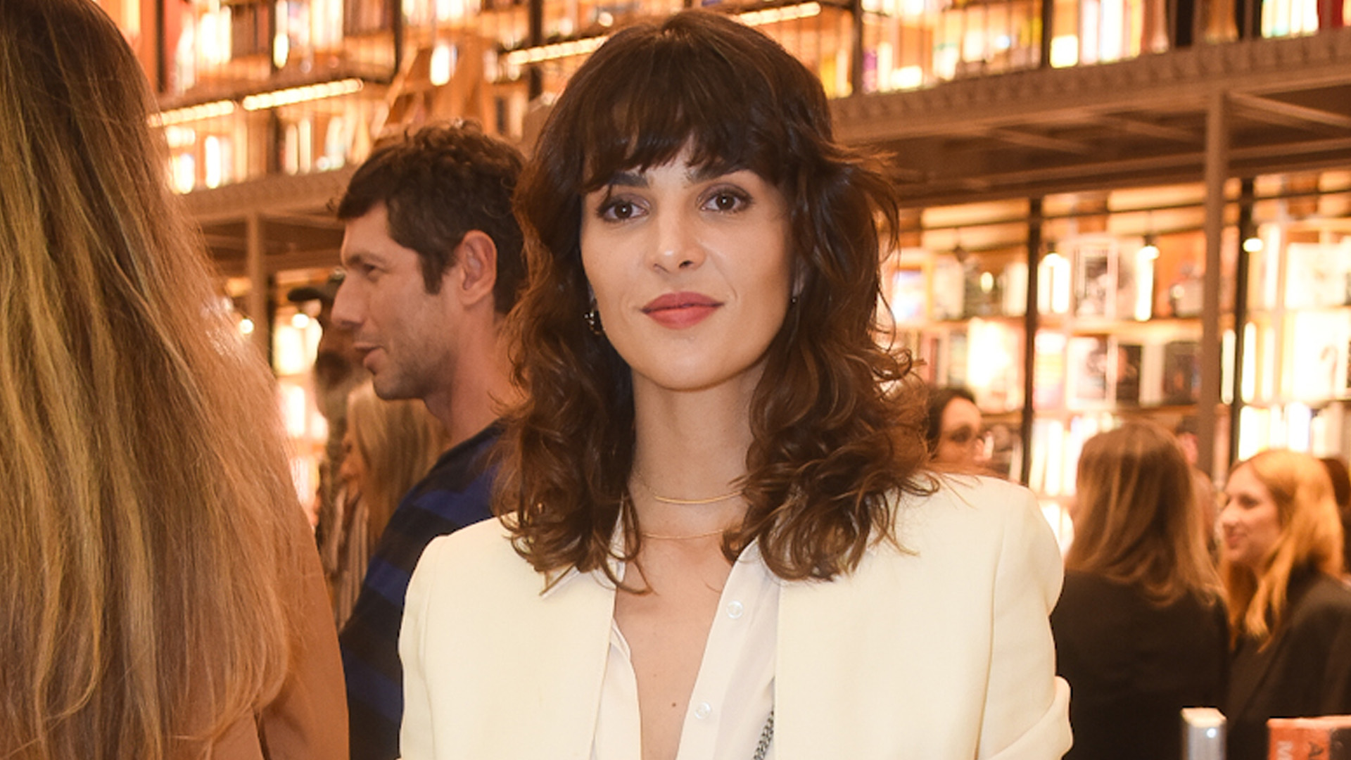 Esposa de Junior Lima, Mônica Benini deixa camisa aberta e sutiã fica à mostra em evento